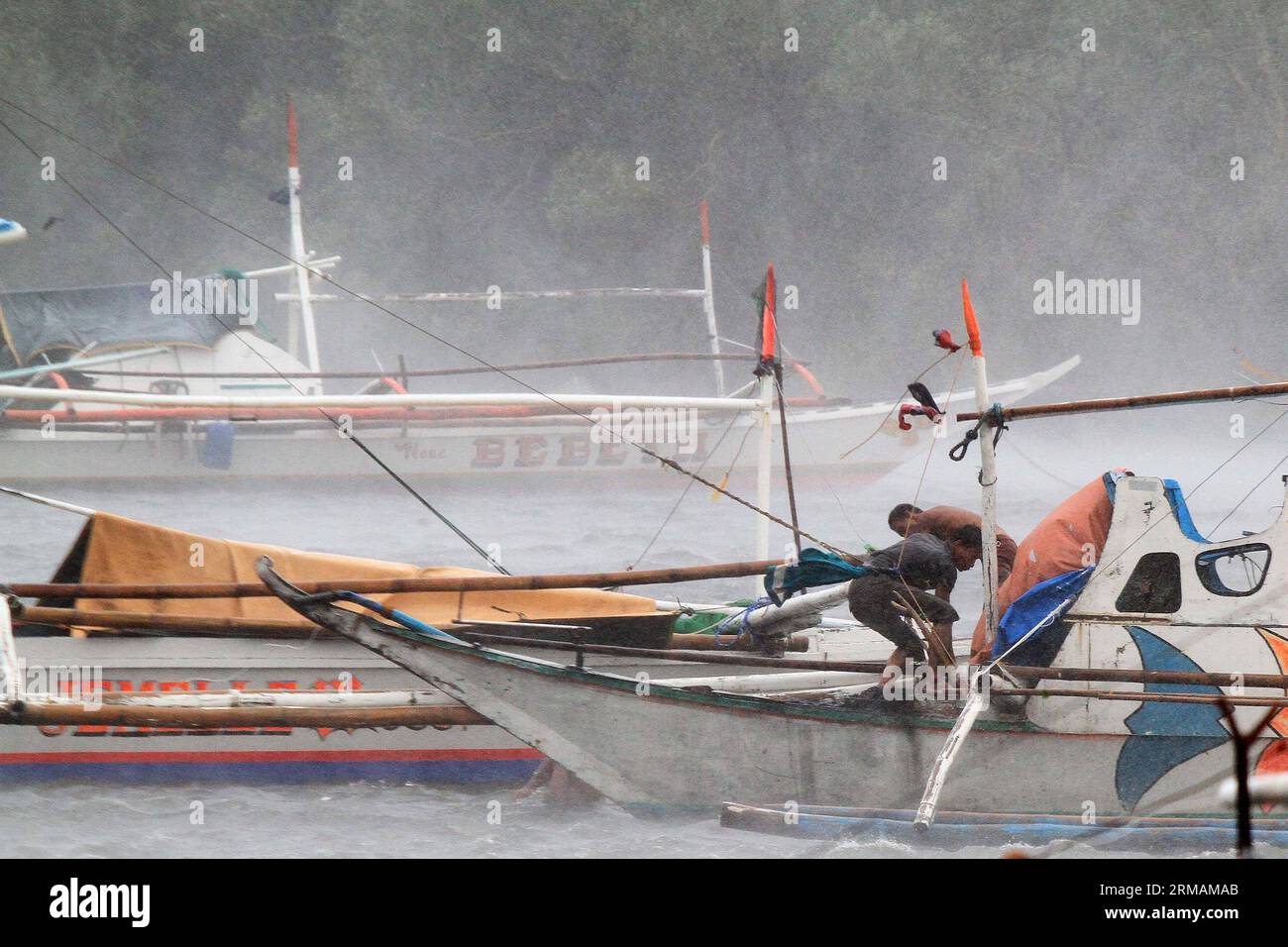 (140716) -- PROVINZ CAVITE, 16. Juli 2014 (Xinhua) -- Fischer versuchen, ihr Boot zu sichern, während sie den starken Winden des Taifuns Rammasun in der Provinz Cavite, Philippinen, am 16. Juli 2014 trotzen. Mindestens 5 Menschen wurden getötet, nachdem der Taifun Rammasun (lokaler Name: Glenda) am Mittwoch die philippinische Hauptstadt Metro Manila lahmlegte. (Xinhua/Rouelle Umali) PHILIPPINEN-CAVITE PROVINZ-TAIFUN RAMMASUN PUBLICATIONxNOTxINxCHN Provinz Cavite Juli 16 2014 XINHUA Fischer versuchen, ihr Boot zu sichern, während sie den starken Winden des Taifuns in der Provinz Cavite auf den PHILIPPINEN trotzen Stockfoto