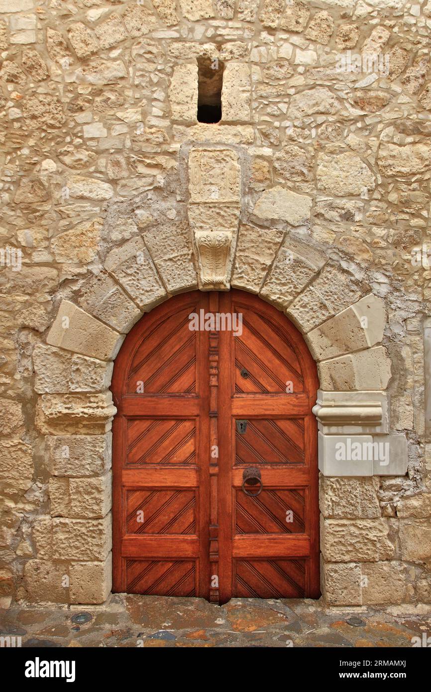 Wunderschöne alte traditionelle Tür mit kunstvollem Steinbogen-förmigen Sturz, in dem malerischen Dorf Margarites, in der Region Rethymno, Kreta, Griechenland Stockfoto
