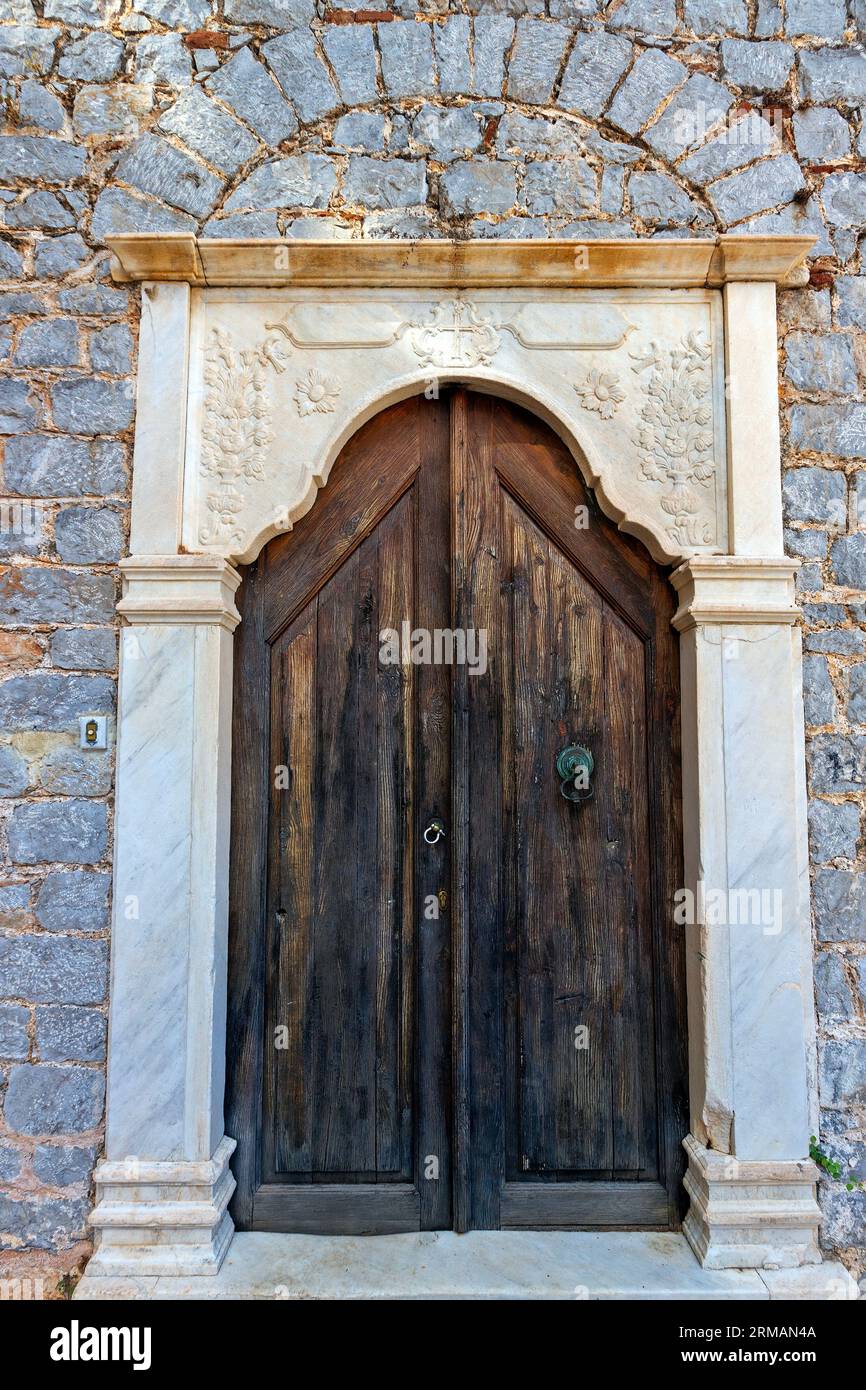 Alte Holztür eines Herrenhauses mit verziertem Sturz, in Hydra Stadt, Hydra Insel, Attika, Griechenland, Europa. Stockfoto