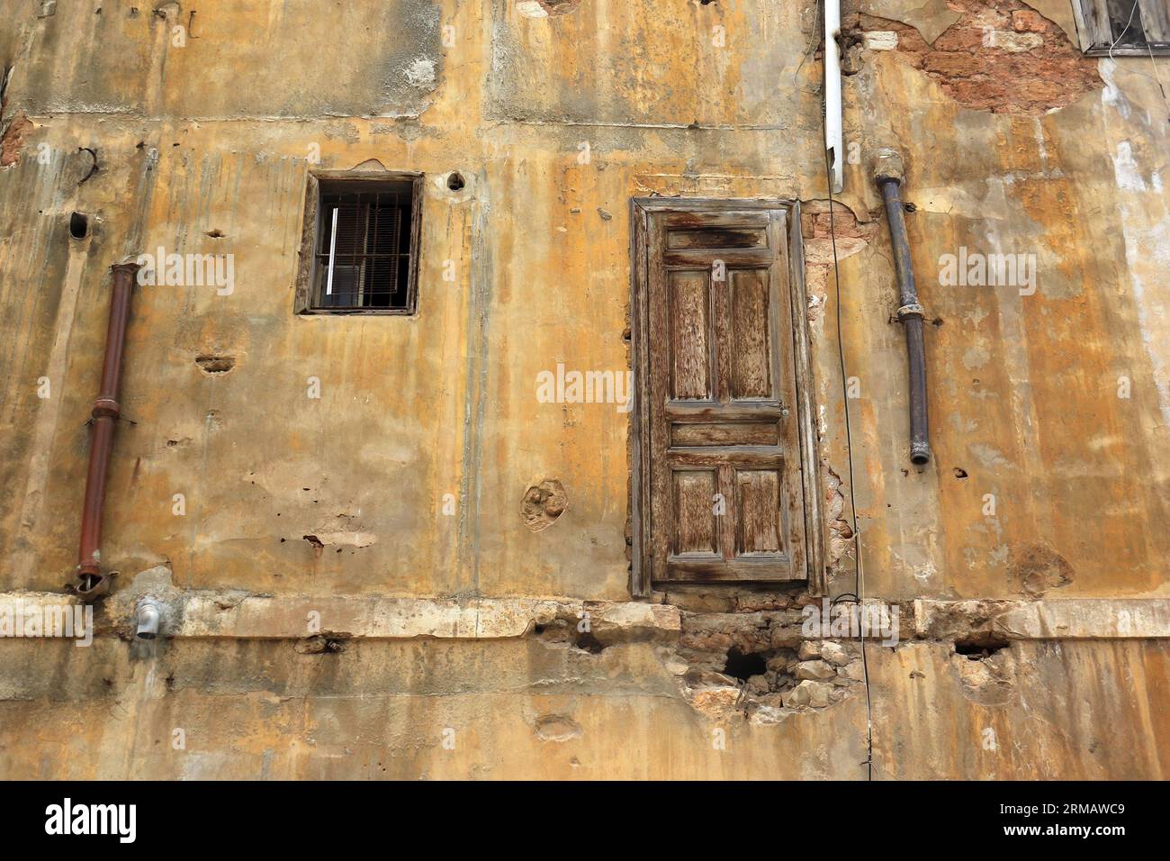 Blick auf eine Hauswand im Freien mit einer geschlossenen Tür, die nirgendwo hinführt. Stockfoto