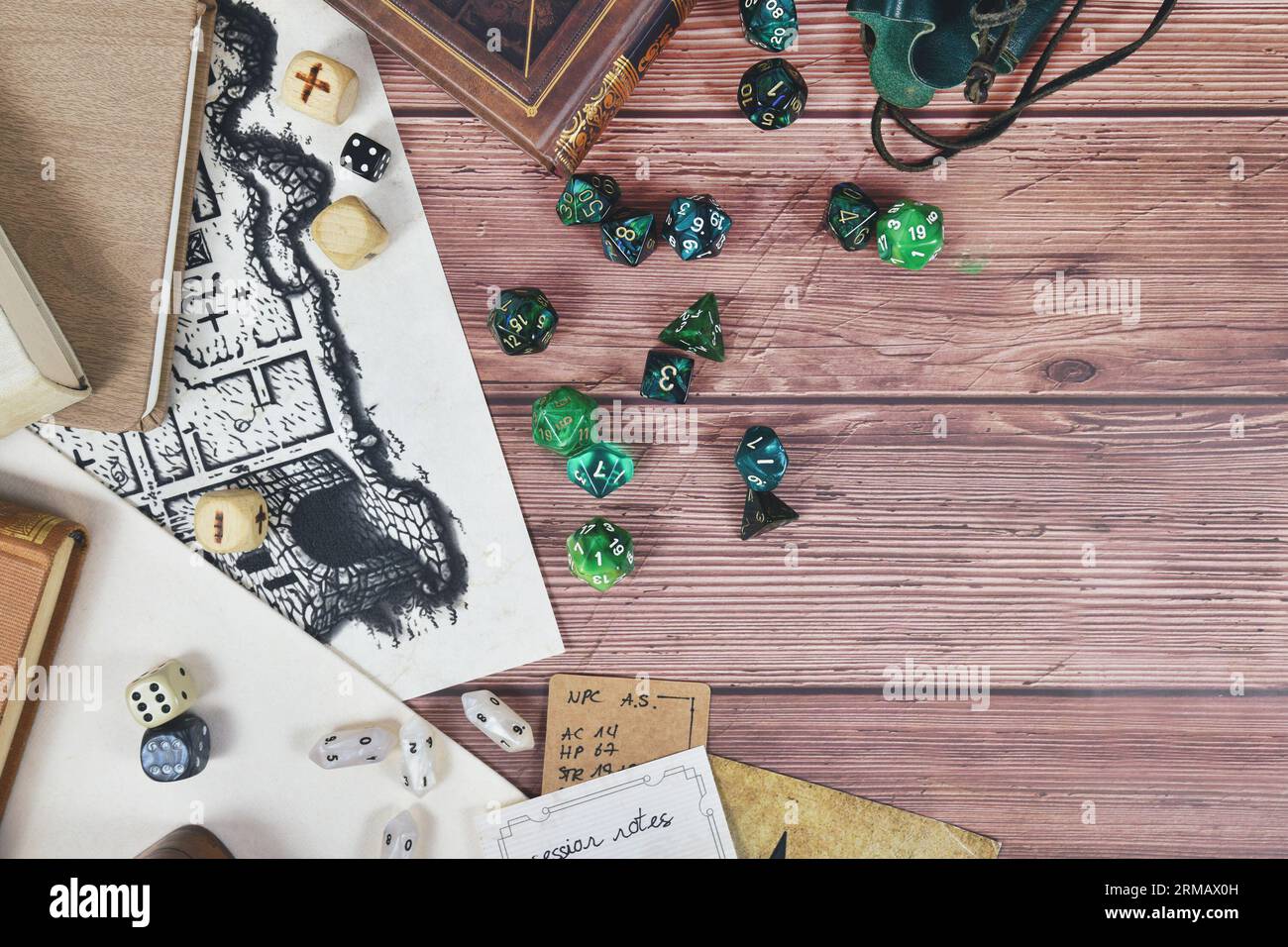 Tischrollenspiel flach liegender Hintergrund mit bunten Rollenwürfeln, Regelbüchern und Notizen auf Holzhintergrund mit Platz zum Kopieren Stockfoto