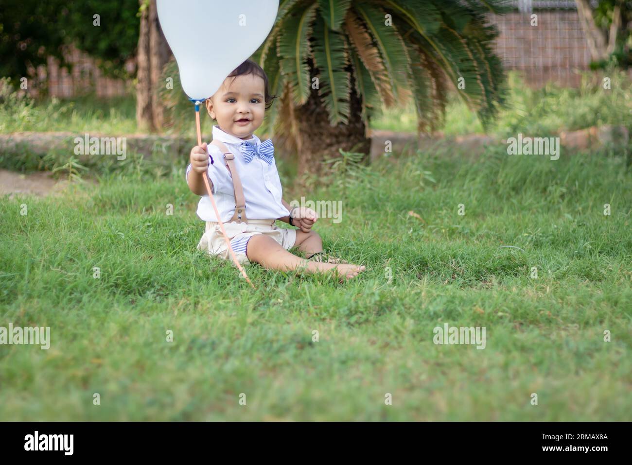 Isoliertes süßes Kleinkind mit unschuldigem Gesichtsausdruck im Freien aus verschiedenen Blickwinkeln am Tag Stockfoto