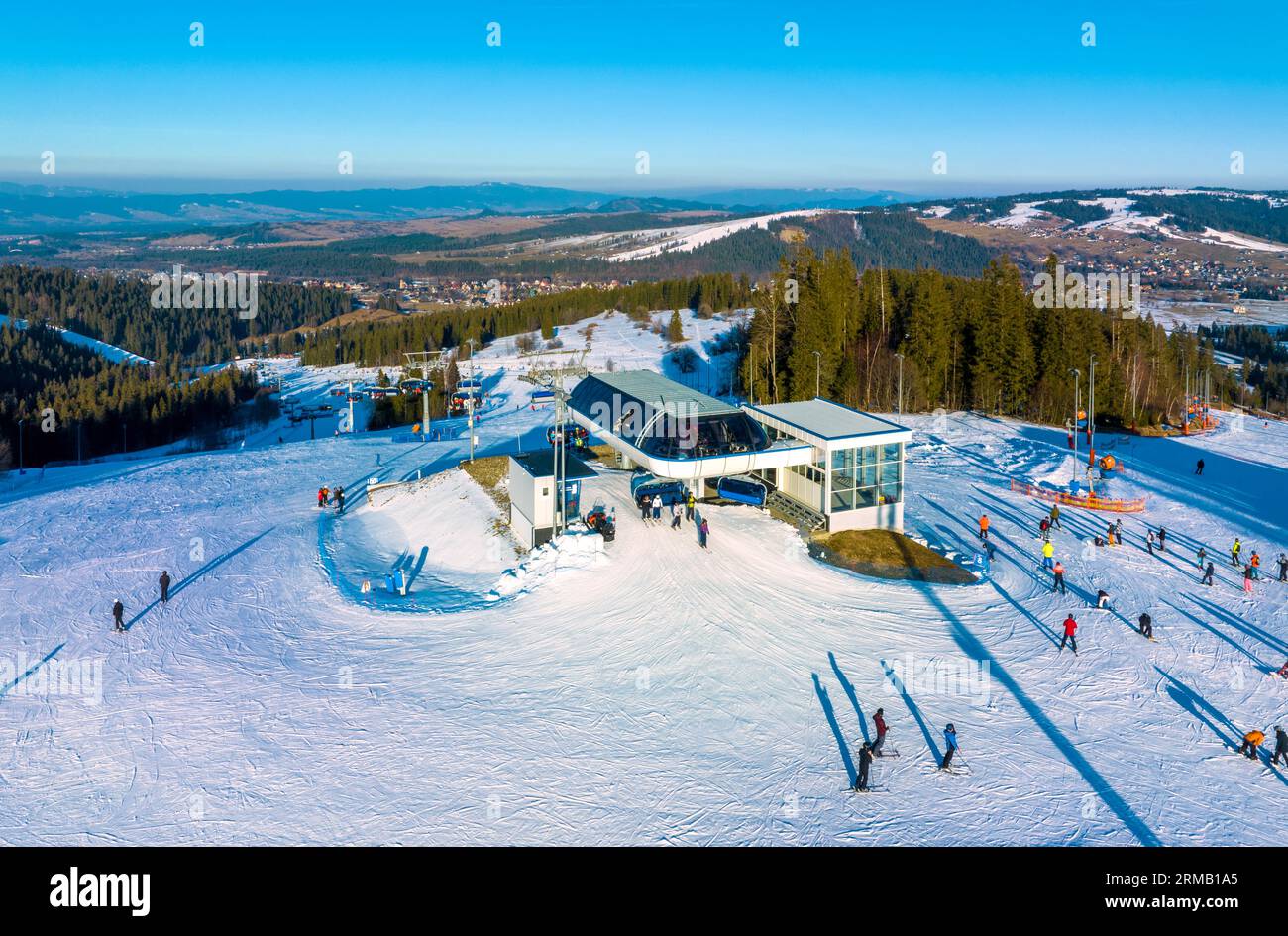 Skipiste, Sessellift, Skifahrer und Snowboarder im Skigebiet Bialka Tatrzanska in Polen auf dem Berg Jankulakowski Wierch im Winter. Luftaufnahme in der Sonne Stockfoto
