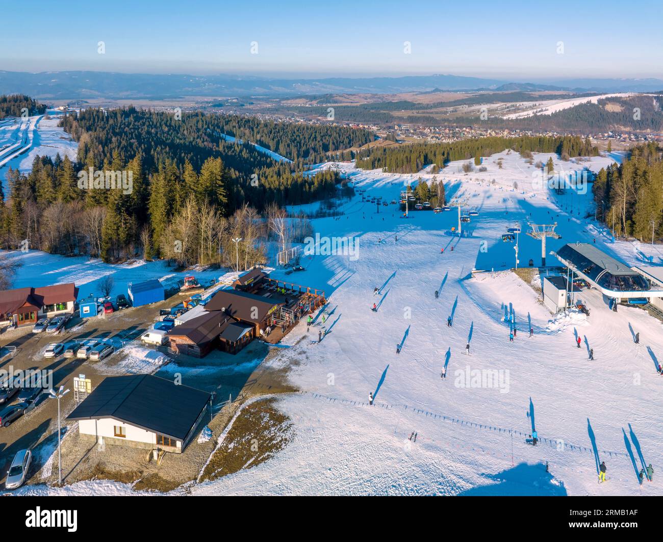 Skipiste, Sessellift, Skifahrer und Snowboarder im Skigebiet Bialka Tatrzanska in Polen auf dem Berg Jankulakowski Wierch im Winter. Luftaufnahme in der Sonne Stockfoto