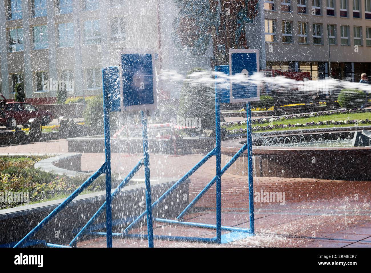 Ein nasser, kraftvoller Wasserstrahl spritzt und schießt auf das Ziel, mit viel Druck auf die Straße bei der Attraktion, Wettbewerben. Stockfoto