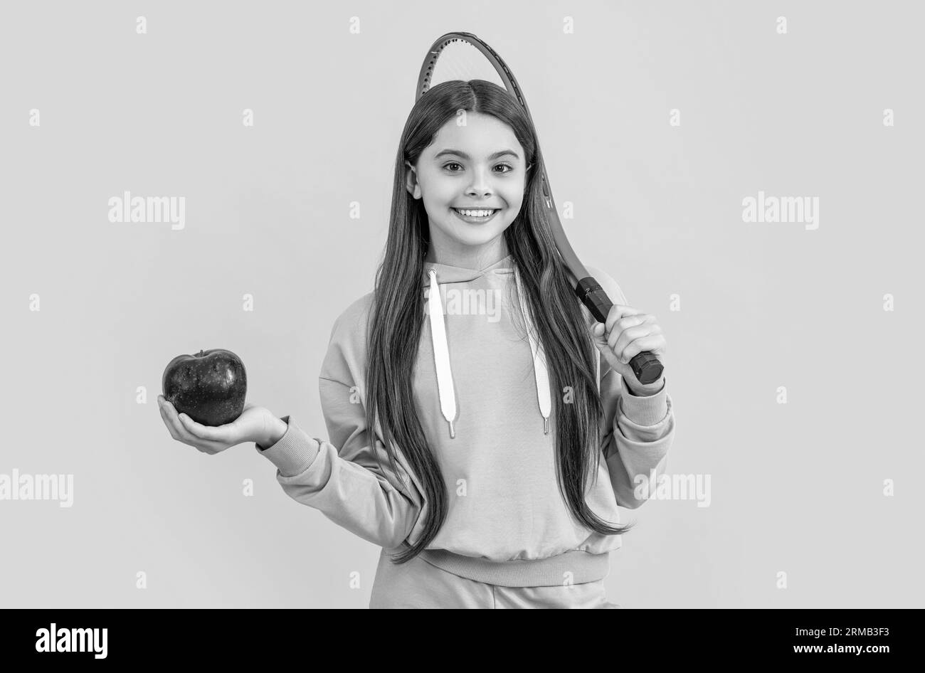Teenager-Tennismädchen im Studio. Teenager-Tennis-Mädchen im Hintergrund. Foto von Teenager Tennis Girl mit Apfel. Stockfoto