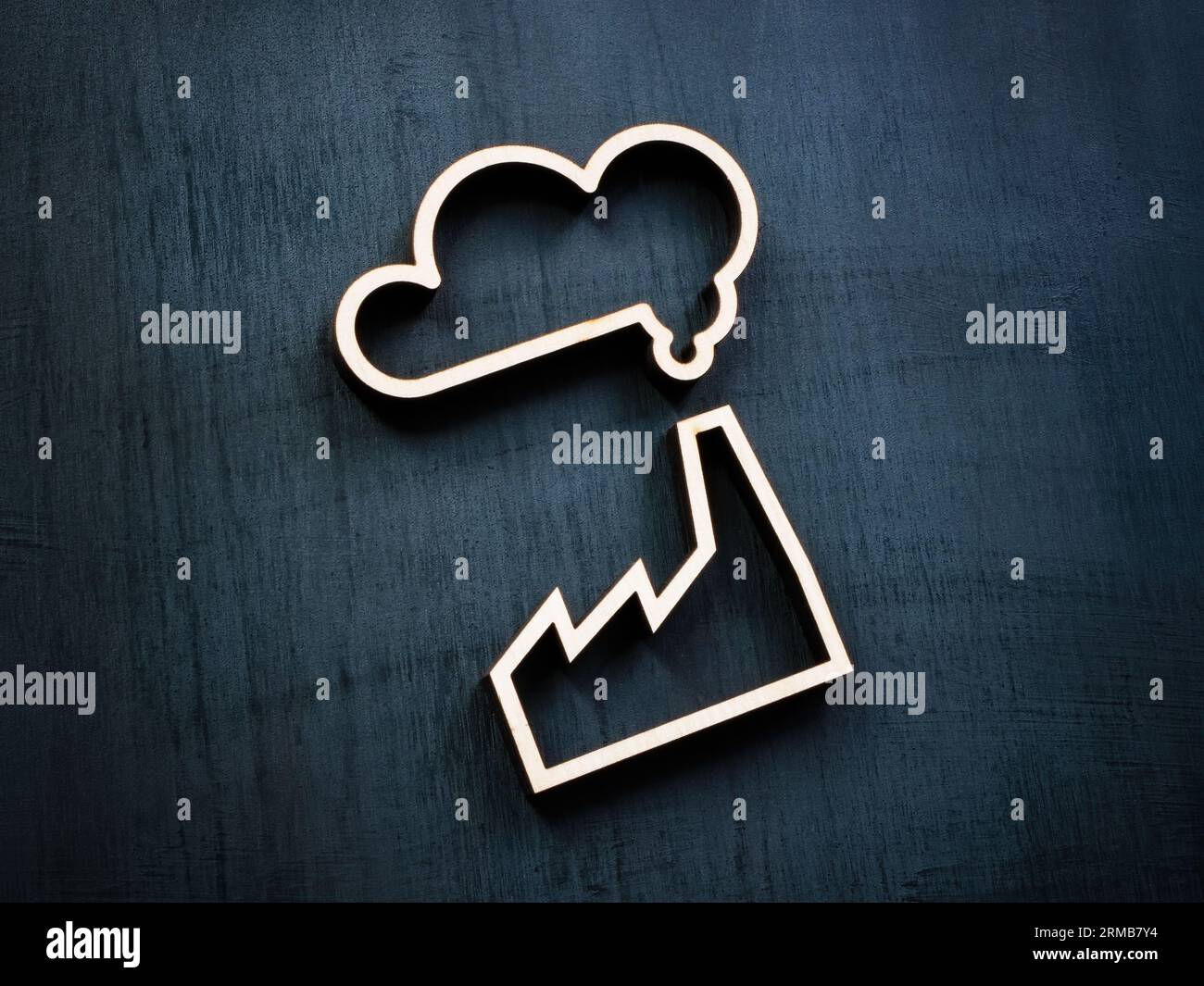 Holzmodell einer Fabrik mit Wolke als Symbol der Umweltverschmutzung. Stockfoto