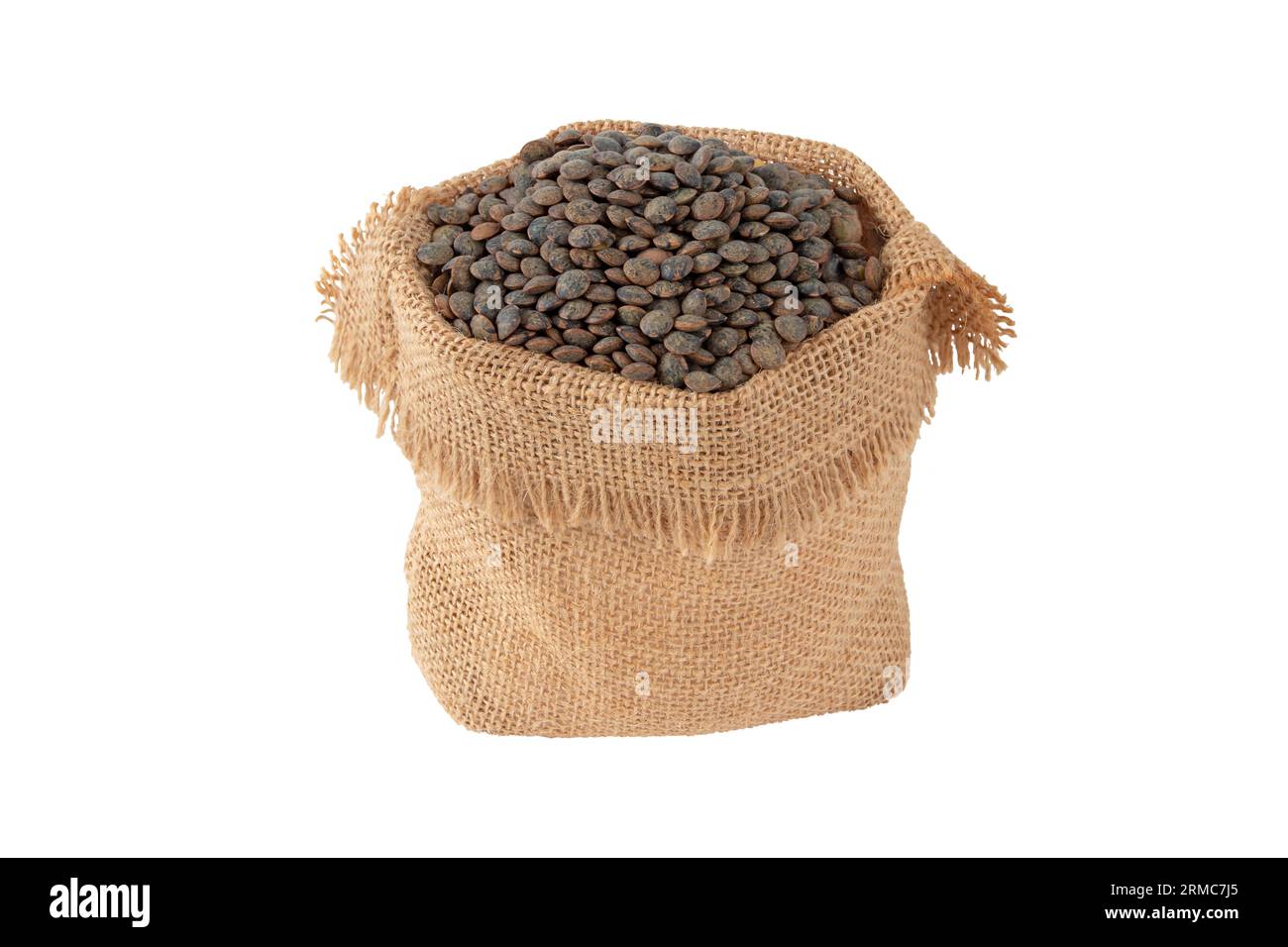 Dunkle Linsen im Jutesack isoliert auf weiß. Ungekochte, rohe Hülsenfrüchte. Stockfoto