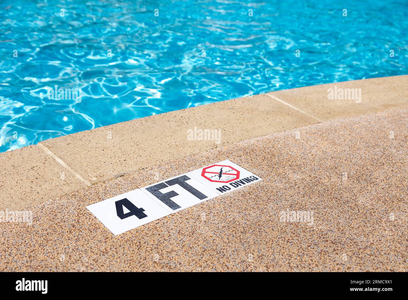 Rand des Swimmingpools ohne Tauchen-Warnschild und 4 Fuß Tiefenmarkierung Stockfoto
