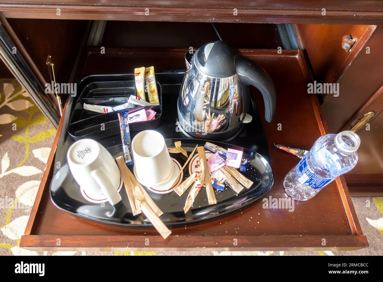 Schubladentablett mit Wasserkocher, Tassen, gebrauchte Kaffeebeutel, verdreckt. Kaffeetrinken in Hotels. Der Kaffee im Hotelzimmer war unordentlich Stockfoto