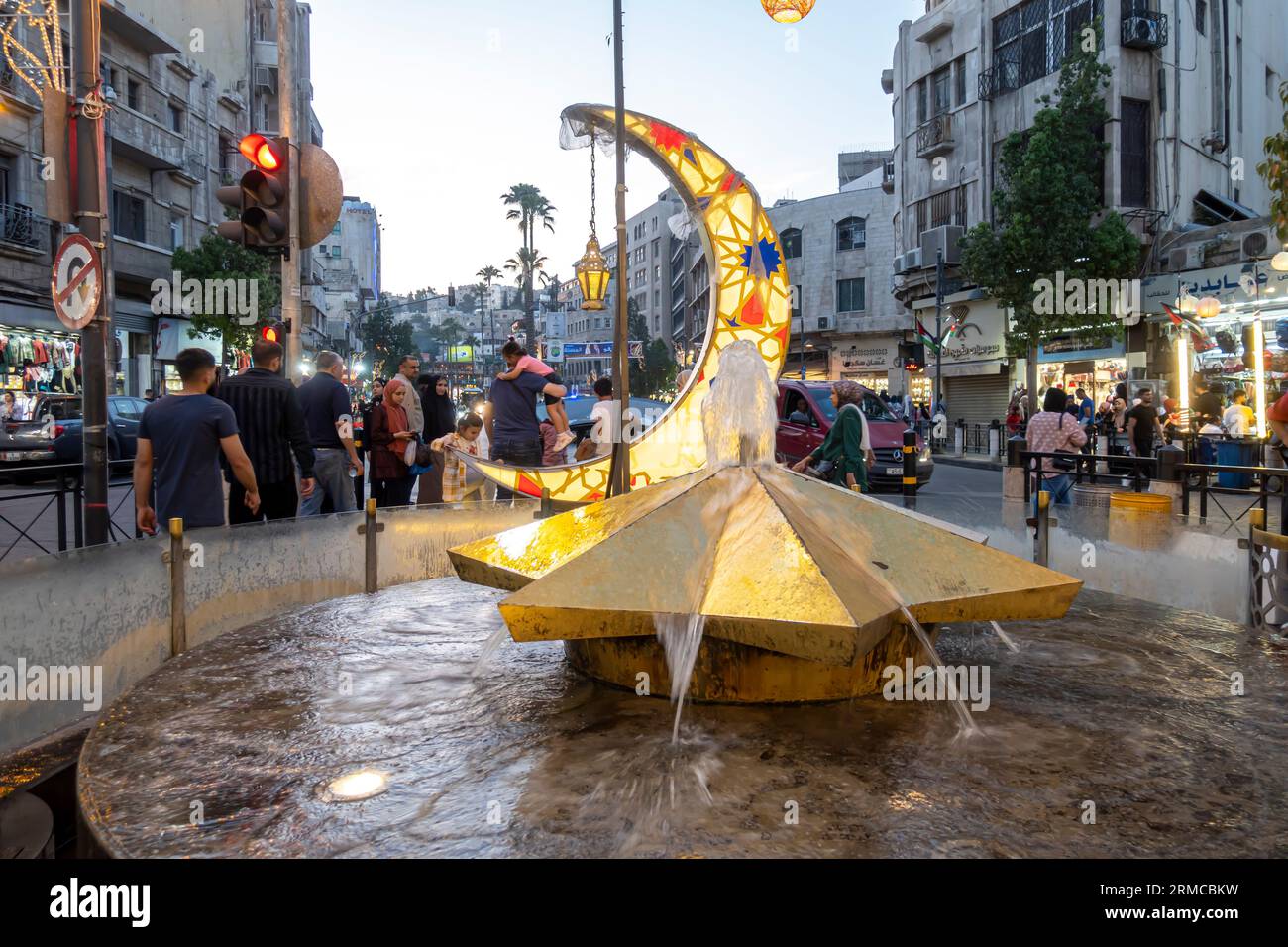 Jabal Amman Straßendekoration - Halbmond und Springbrunnen in Form eines Sterns. Jordanische Leute kommen am Straßenabend vorbei. Jabal al-Weibdeh Stockfoto