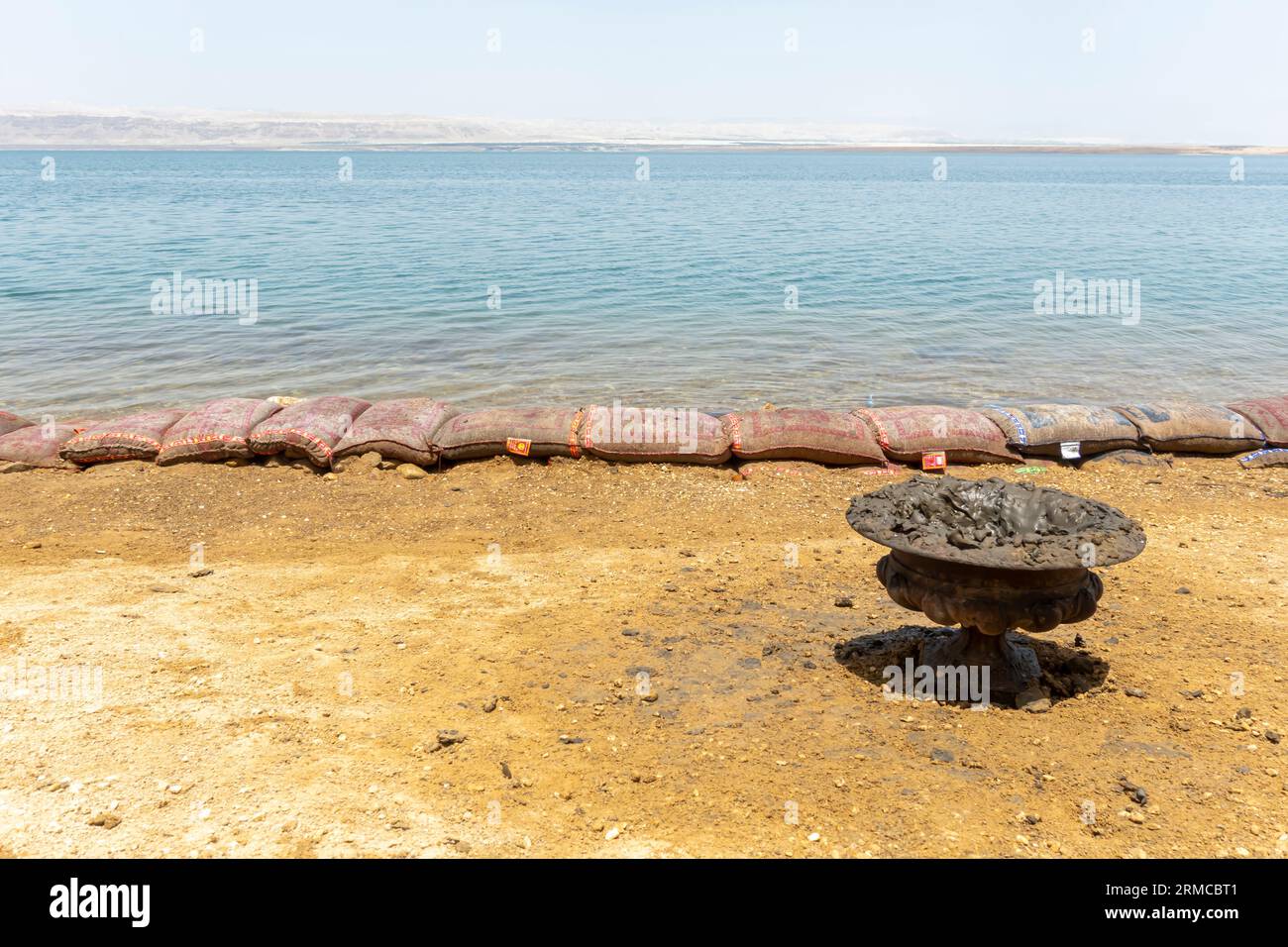 Schüssel mit Schlamm zum Auftragen auf den Körper vor dem Schwimmen im Toten Meer Jordan am Strand, Seebad Stockfoto