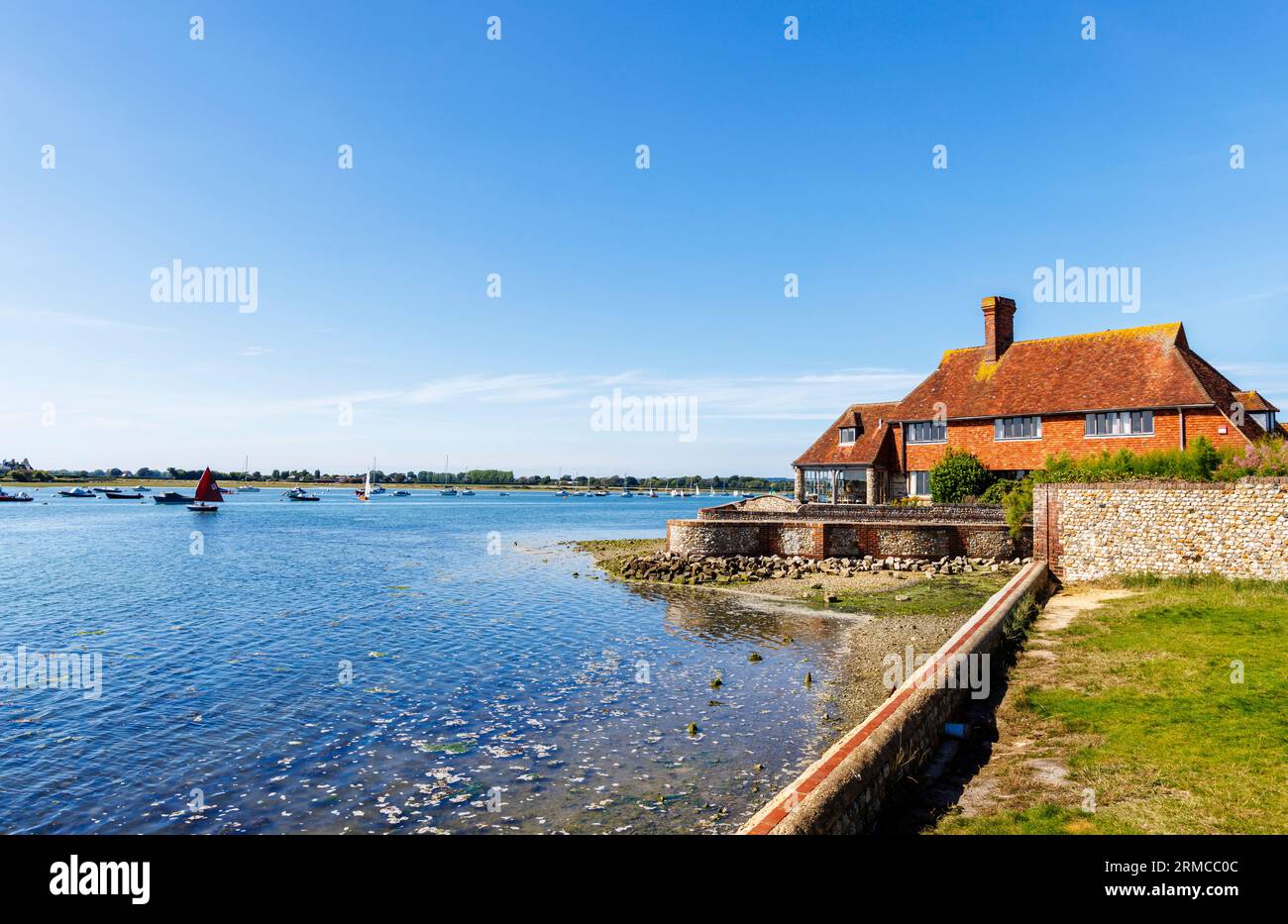 Ein großes Haus am Wasser am Bosham Quay, Bosham, ein Küstendorf an der Südküste von Chichester Harbour, West Sussex, Südengland Stockfoto