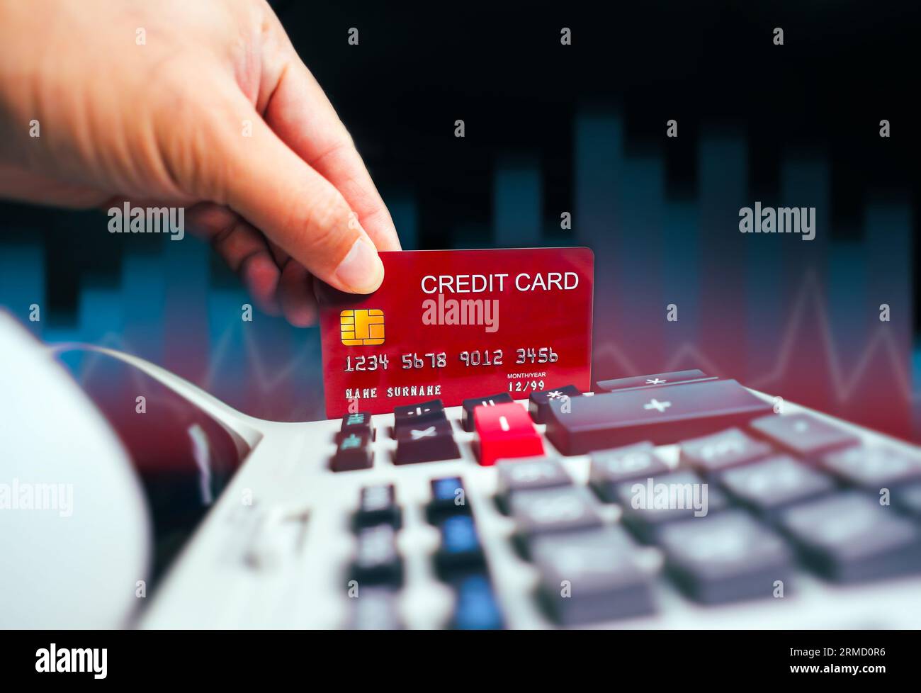 Finanzkrise und Kreditkartenkonzept, rote Kreditkarte mit Taschenrechner und verschwommenes Geschäftsdiagramm im Hintergrund, Kreditkartenkrisen Stockfoto