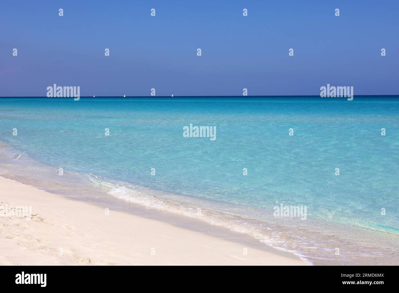 Leerer Strand mit weißem Sand, Blick auf azurblaue Wellen und blauen Himmel mit Wolken. Karibikküste, Hintergrund für Urlaub in paradiesischer Natur Stockfoto