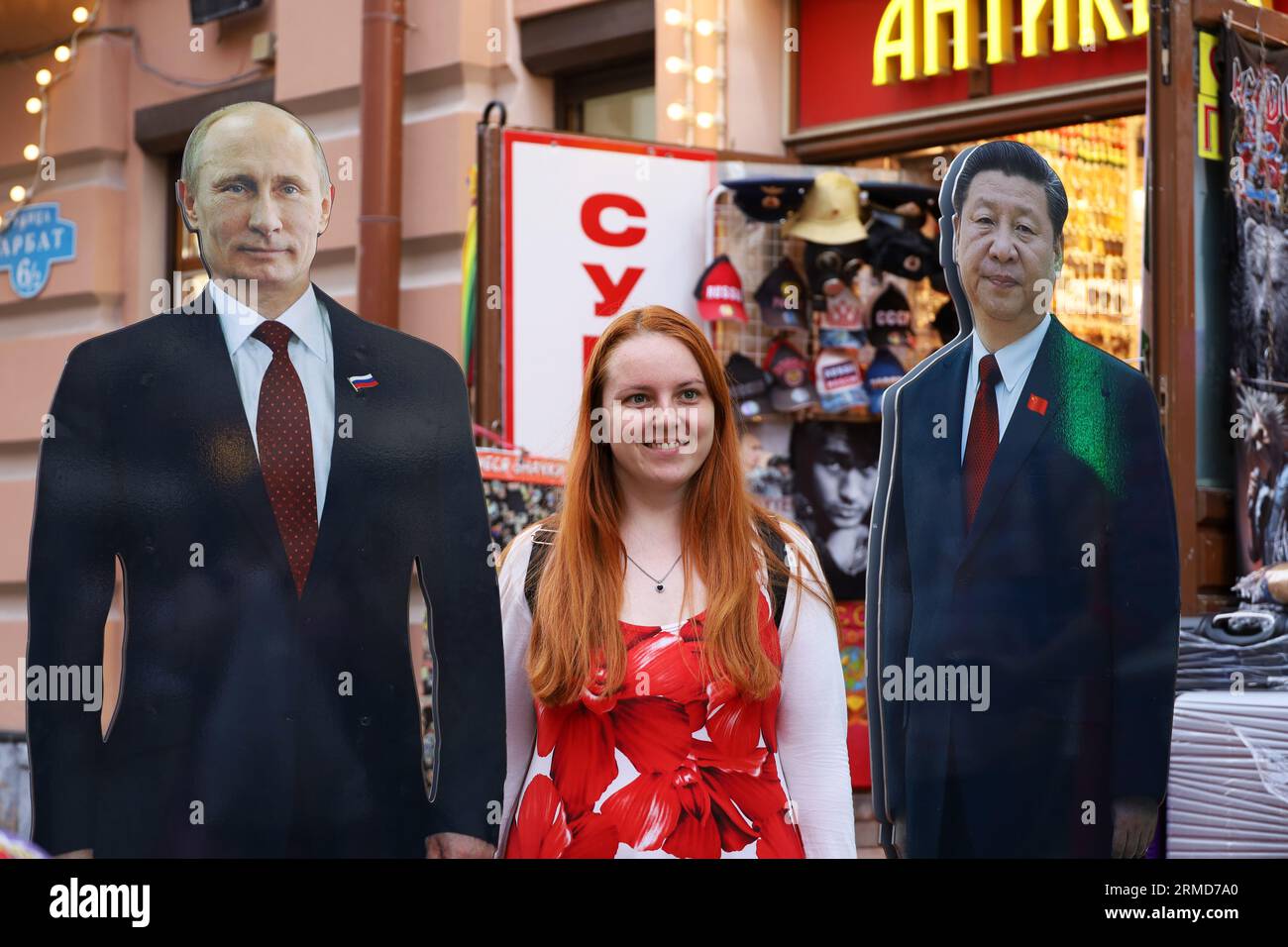 Frau touristische Fotografie mit harten Plakaten von Wladimir Putin und Xi Jinping auf Novy Arbat Straße, Reise in Russland Stockfoto