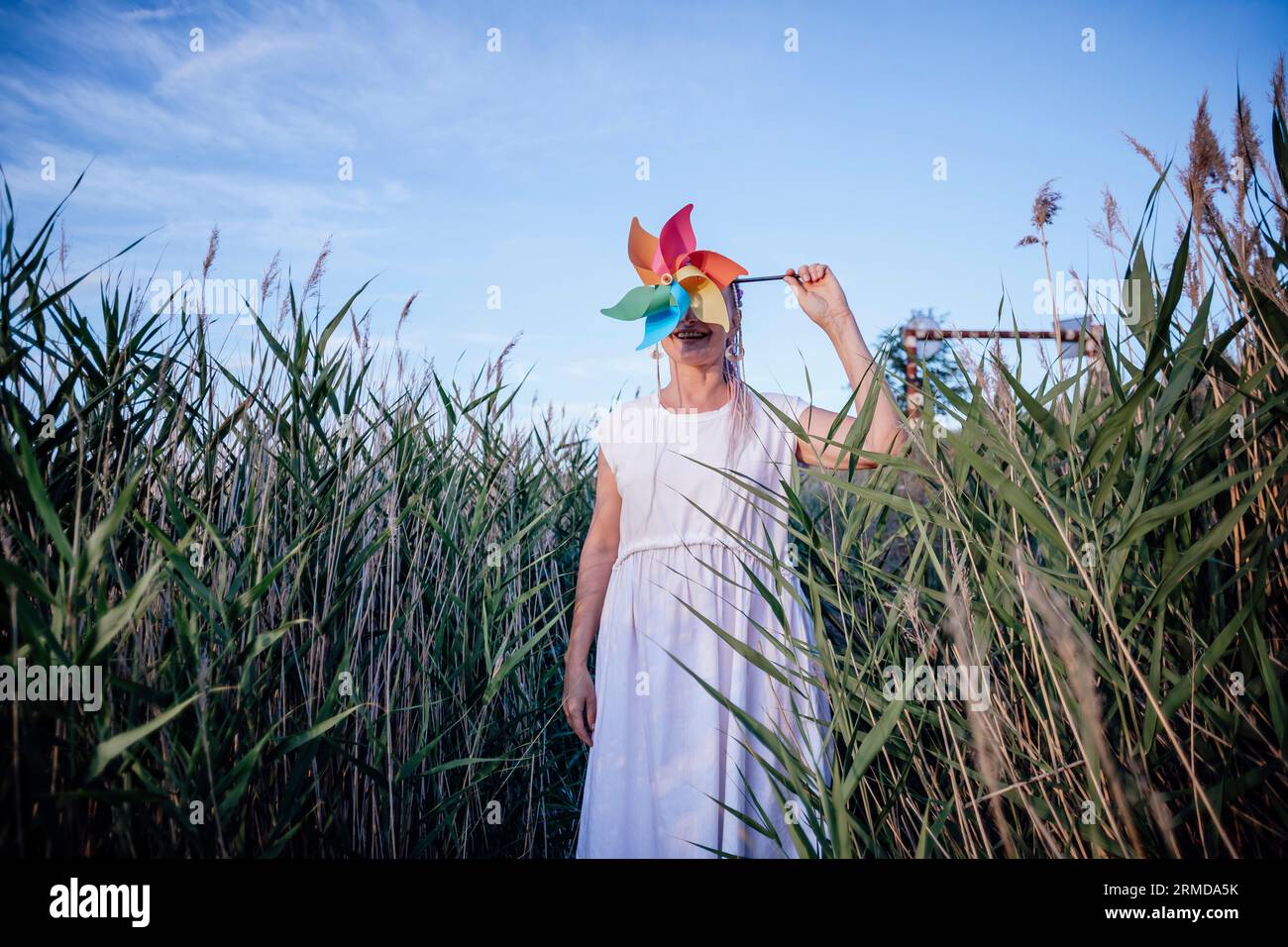 Mädchen mit unerkennbarem Gesicht hält Windmühle, Windenergie Stockfoto