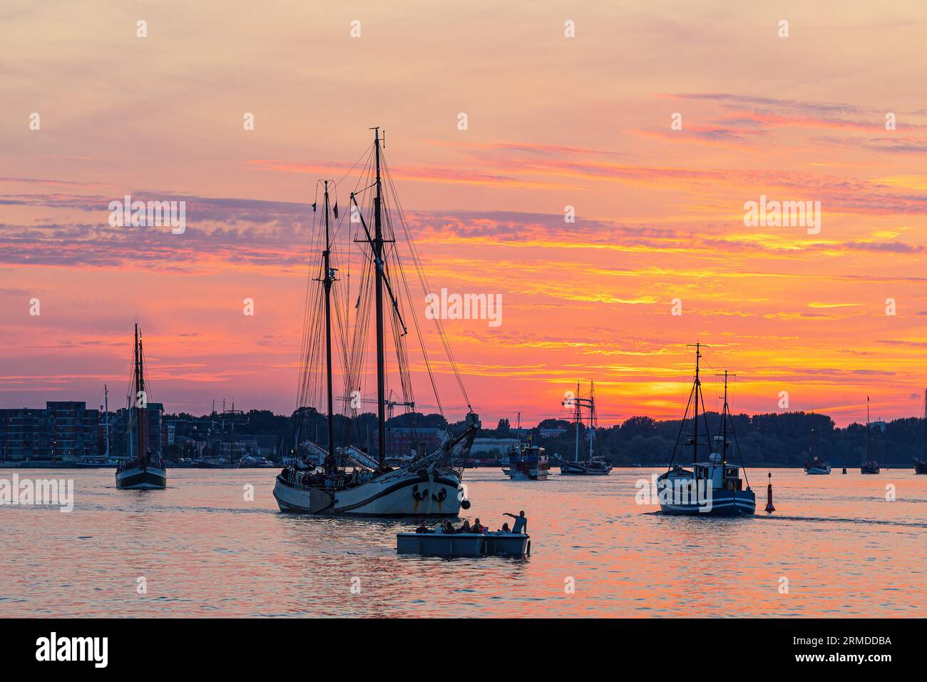 Segelschiffe Auf Dem Warnow Bei Sonnenuntergang Während Der Hanse Sail In Rostock. Stockfoto