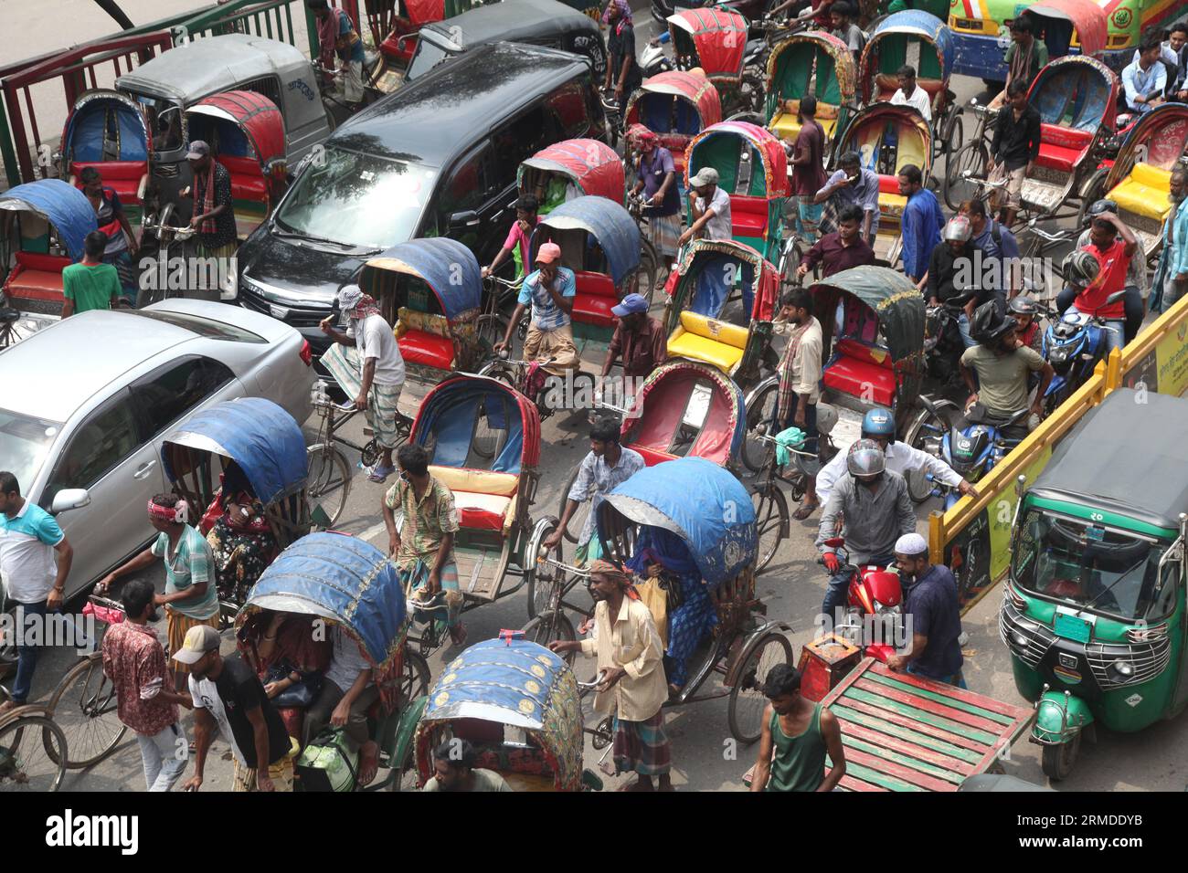 Dhaka, Bangladesch. August 27, 2023. Eine allgemeine Ansicht zeigt, dass Rikscha-Abzieher ihre Kunden in den Verkehr auf der New Market Road in DH transportieren Stockfoto