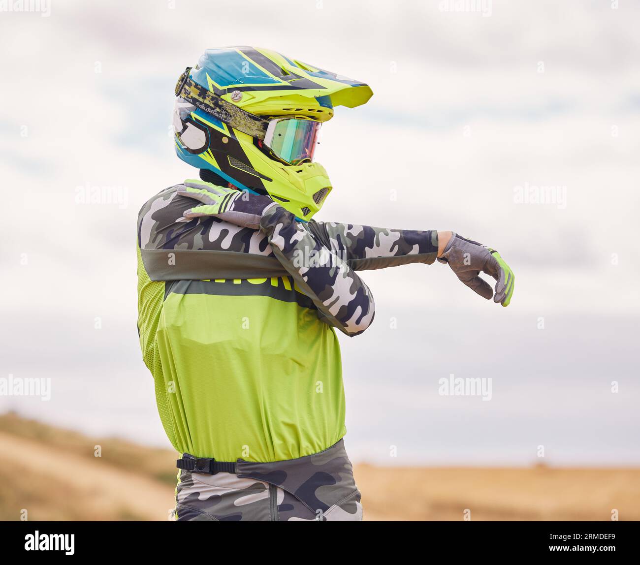 Motorsport, Stretching und Mann mit Helm in der Natur für Training, Workout und Leistung für Rennen. Reise, Motorrad und Person im Freien bereit für Stockfoto