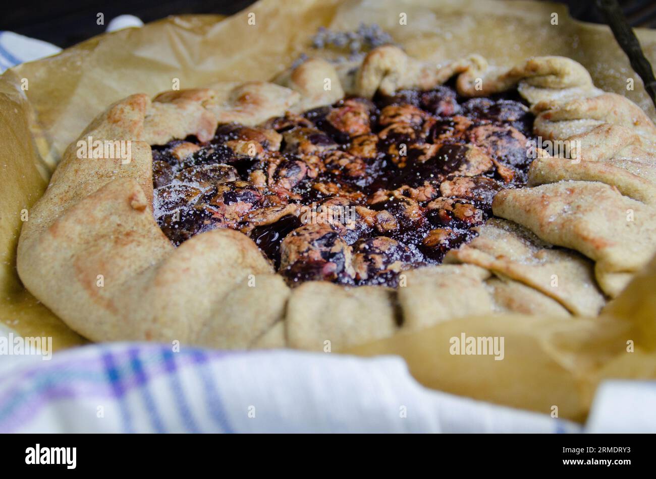 Pflaumenobst Galette Kuchen Crostata auf dem schwarzen Holzschreibtisch mit Leinenstoff Textil und antiken Vintage Silber Besteck Food Fotografie Stockfoto