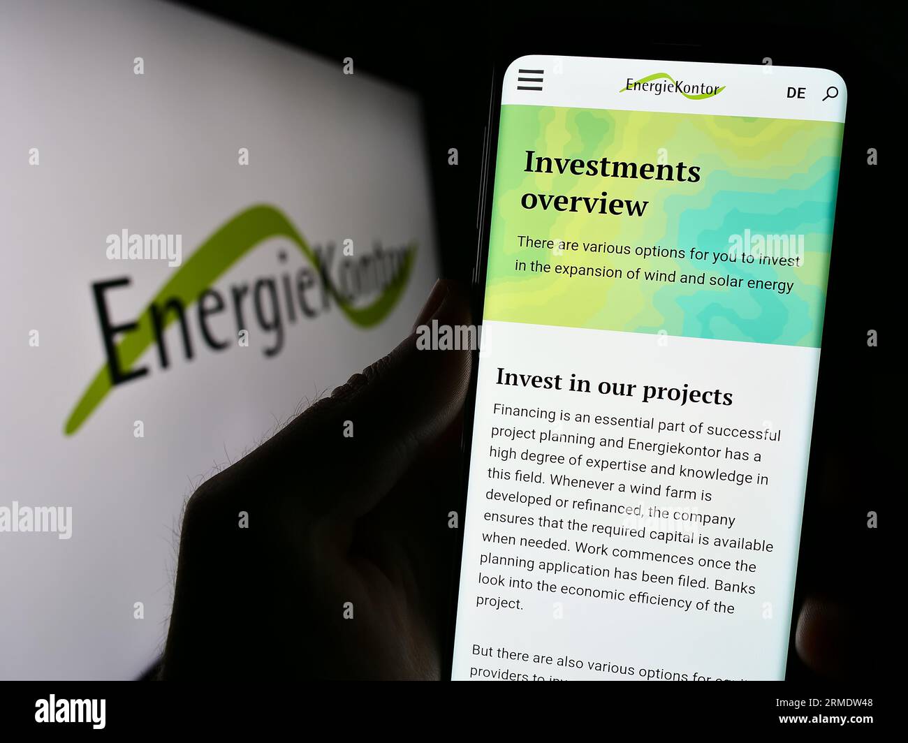 Person mit Smartphone mit Website des deutschen Erneuerbare-Energien-Unternehmens Energiekontor AG auf dem Bildschirm mit Logo. Konzentrieren Sie sich auf die Mitte der Telefonanzeige. Stockfoto