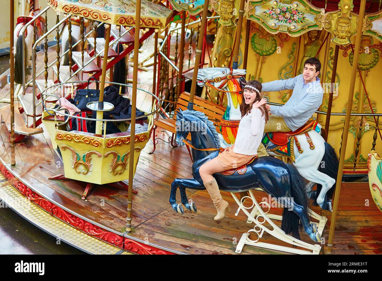 Glückliches Paar auf dem Karussell in Paris, Spaß haben Stockfoto