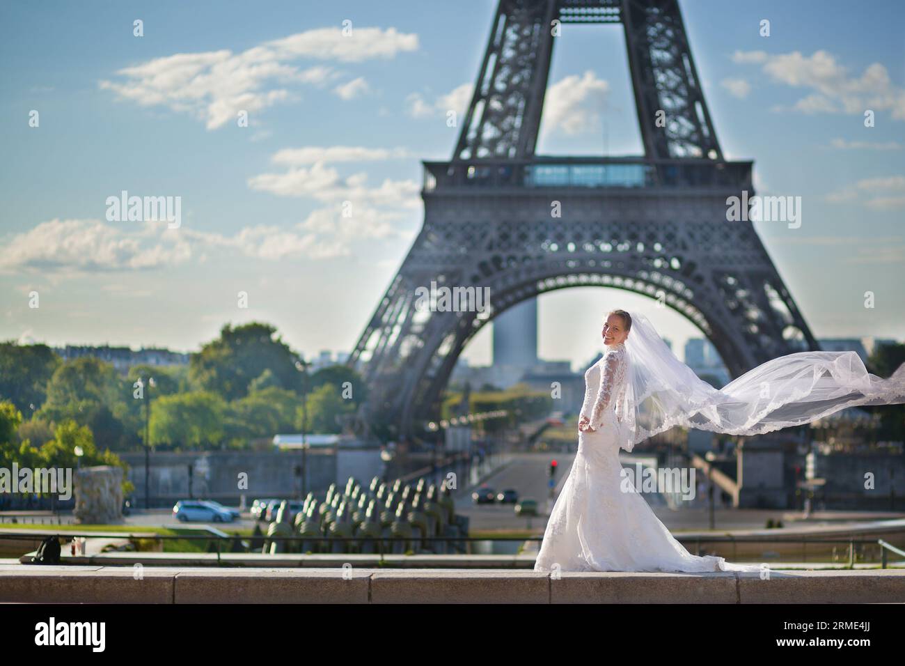 Schöne junge Braut in Paris mit ihrem Schleier, der auf dem Wind winkt Stockfoto