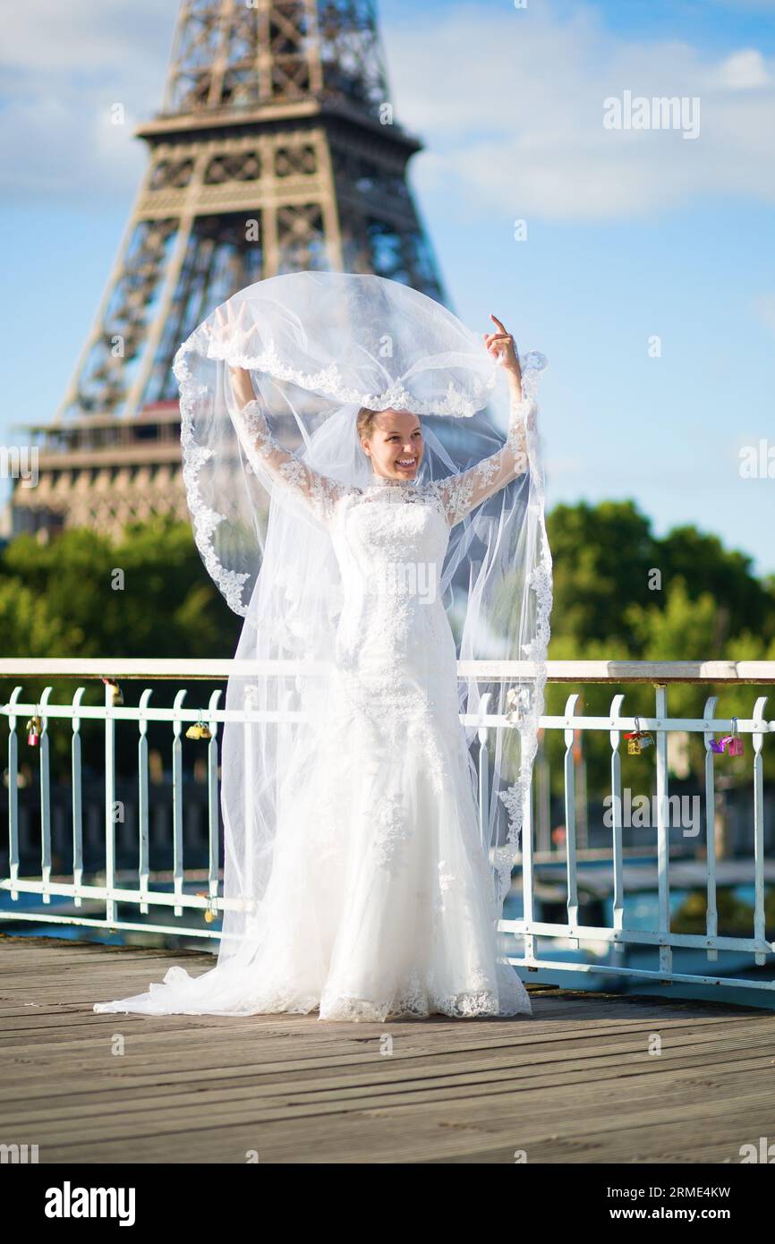 Wunderschöne elegante Braut mit langem Schleier in der Nähe des Eiffelturms in Paris Stockfoto