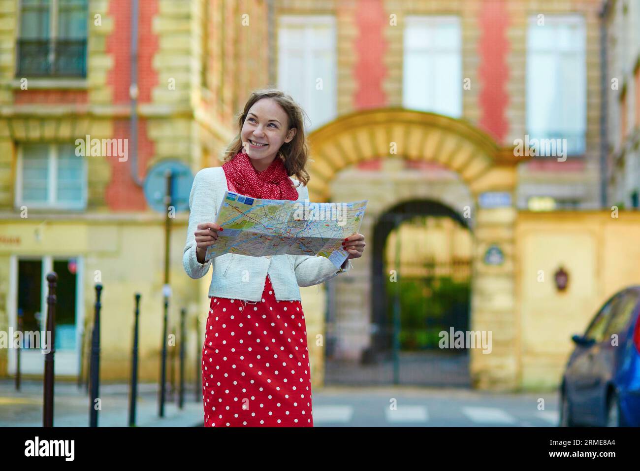 Junge schöne weibliche Touristin mit Karte in Marais Viertel von Paris, auf der Suche nach der Richtung Stockfoto