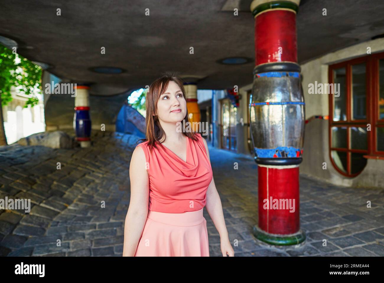 Schöne junge Frau zu Fuß in Wien, Österreich in der Nähe des Hundertwasserhauses Stockfoto