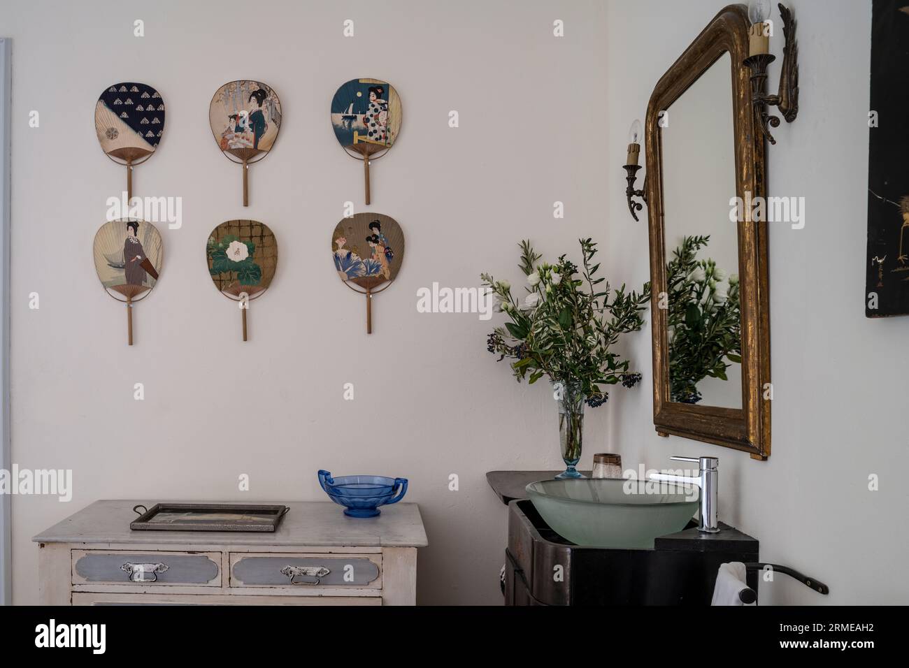Japanische Fans Wandmontage mit vergoldetem gerahmtem Spiegel und Waschbecken Cotignac Schlafzimmer, Var, Frankreich. Stockfoto