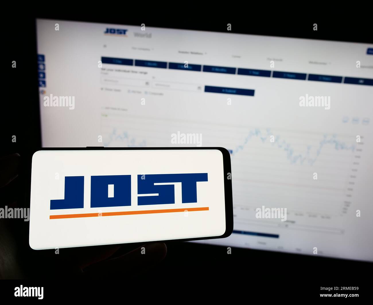 Person, die ein Mobiltelefon mit dem Logo des deutschen Automobilherstellers Jost Werke SE auf dem Bildschirm vor der Business-Webseite hält. Konzentrieren Sie sich auf das Display des Telefons. Stockfoto