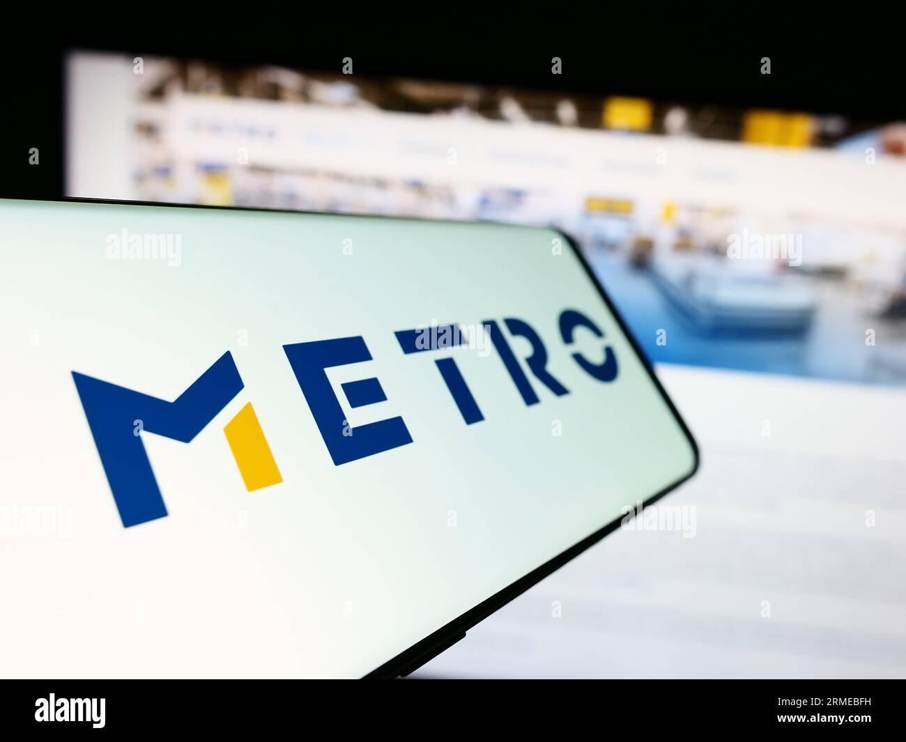 Mobiltelefon mit Logo der deutschen Großhandelsgesellschaft Metro AG auf dem Bildschirm vor der Business-Website. Konzentrieren Sie sich auf die Mitte-links-Anzeige des Telefons. Stockfoto
