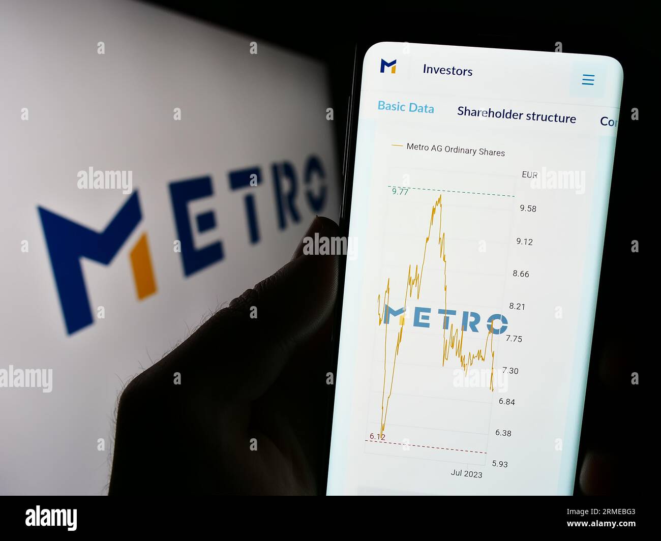 Person, die ein Smartphone mit einer Webseite des deutschen Großhandelsunternehmens Metro AG auf dem Bildschirm vor dem Logo hält. Konzentrieren Sie sich auf die Mitte der Telefonanzeige. Stockfoto