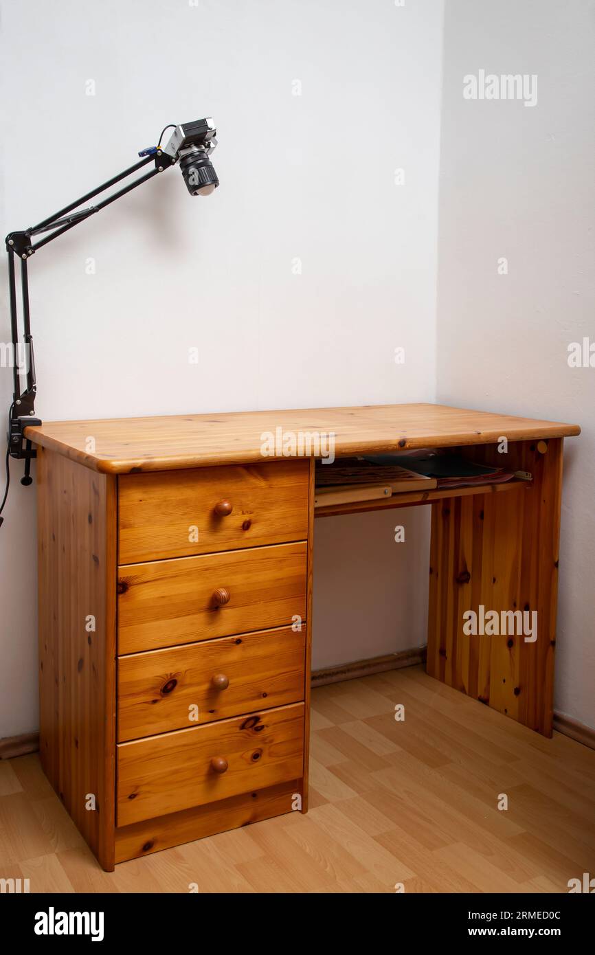Leerer Schreibtisch aus Holz, in einer Ecke mit weißen Wänden Stockfoto