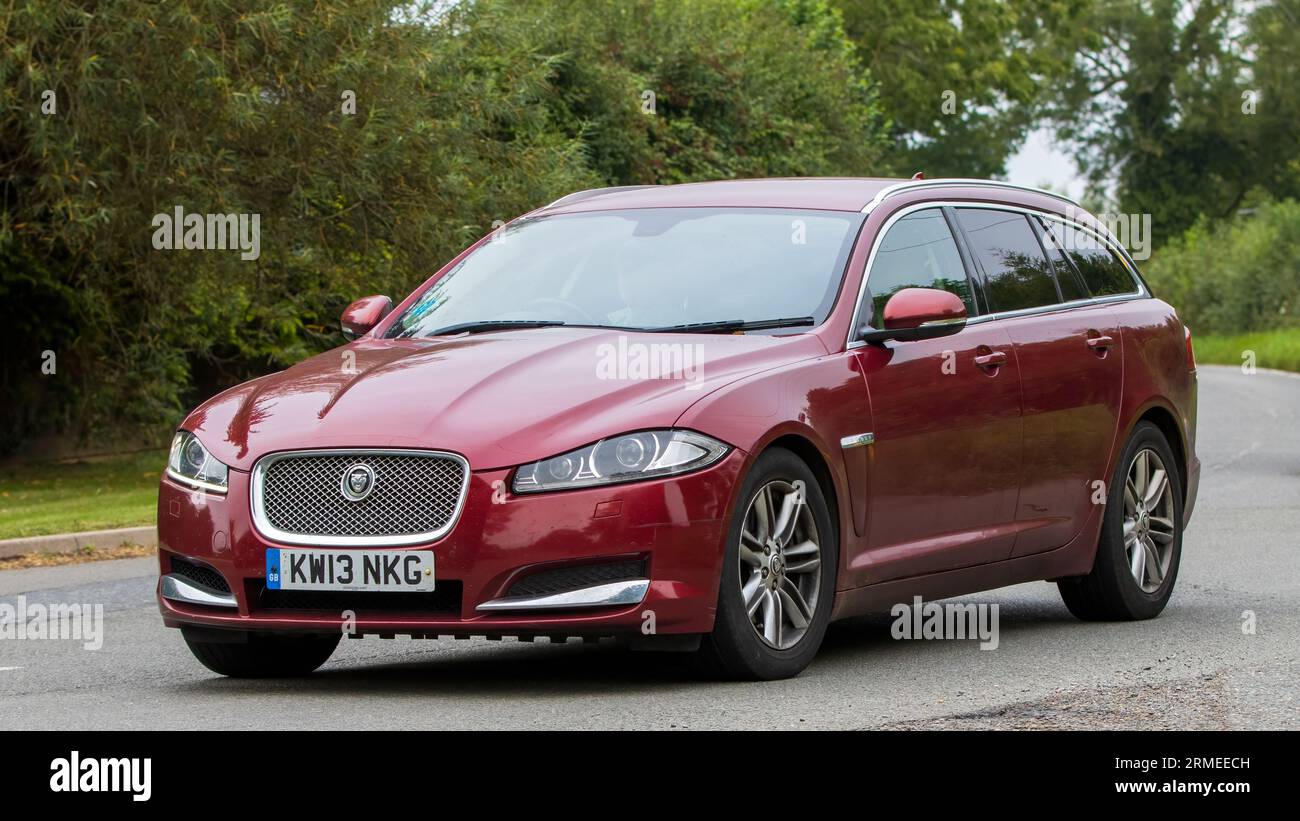 Whittlebury, Northants, UK - 26. August 2023: 2013 roter Jaguar XF Luxus sportbrake V6 Dieselmotor, der auf einer englischen Landstraße fährt Stockfoto