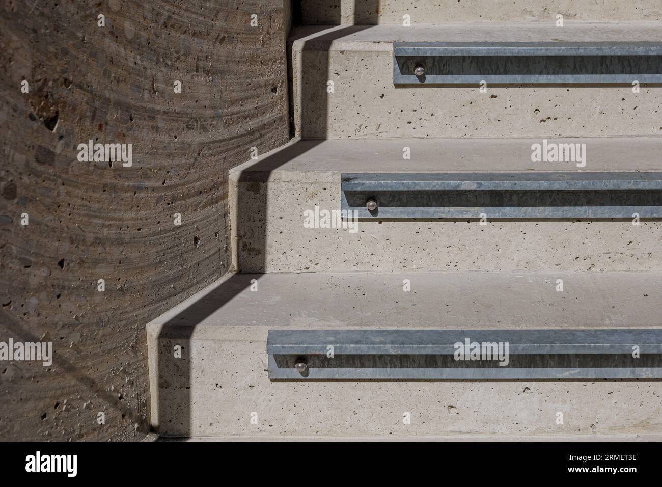 Selektives Fokusdetail der Aluminiumprofil-Treppenschnalle für rutschfeste Verlängerung von rauer Betontreppe im Freien. Stockfoto