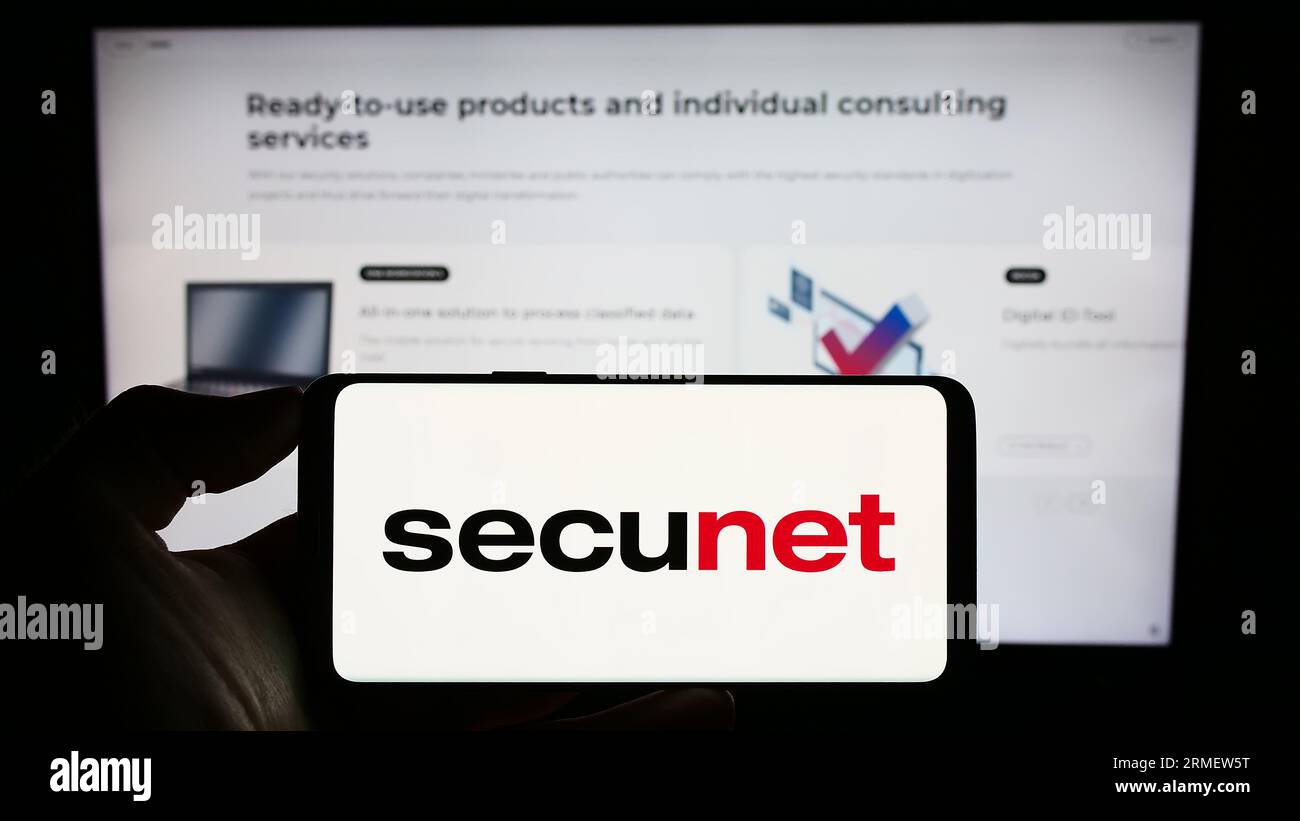Person, die ein Smartphone mit dem Logo der secunet Security Networks AG auf dem Bildschirm vor der Website hält. Konzentrieren Sie sich auf das Display des Telefons. Stockfoto