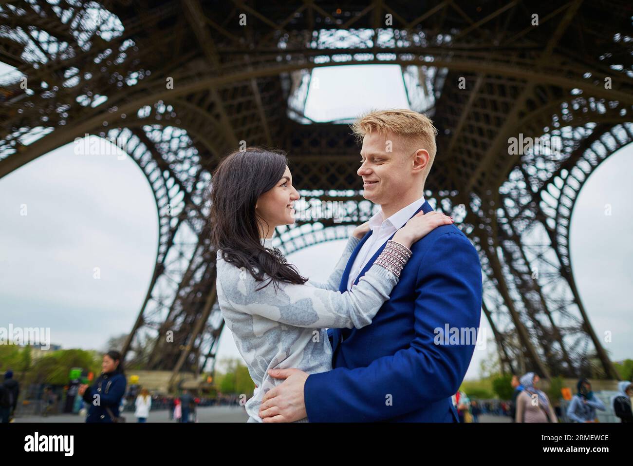 Glückliches Paar unter dem Eiffelturm. Touristen, die ihren Urlaub in Frankreich genießen. Romantisches Date oder Konzept für ein reisendes Paar Stockfoto
