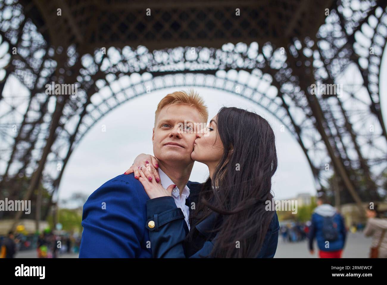 Glückliches Paar unter dem Eiffelturm. Touristen, die ihren Urlaub in Frankreich genießen. Romantisches Date oder Konzept für ein reisendes Paar Stockfoto