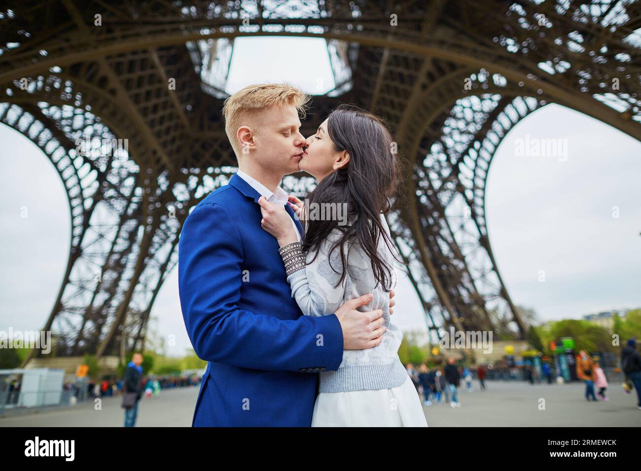 Romantisches Paar, das sich direkt unter dem Eiffelturm küsst Stockfoto