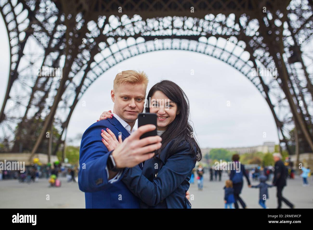 Glückliches Paar macht Selfie unter dem Eiffelturm. Touristen, die ihren Urlaub in Frankreich genießen. Romantisches Date oder Konzept für ein reisendes Paar Stockfoto