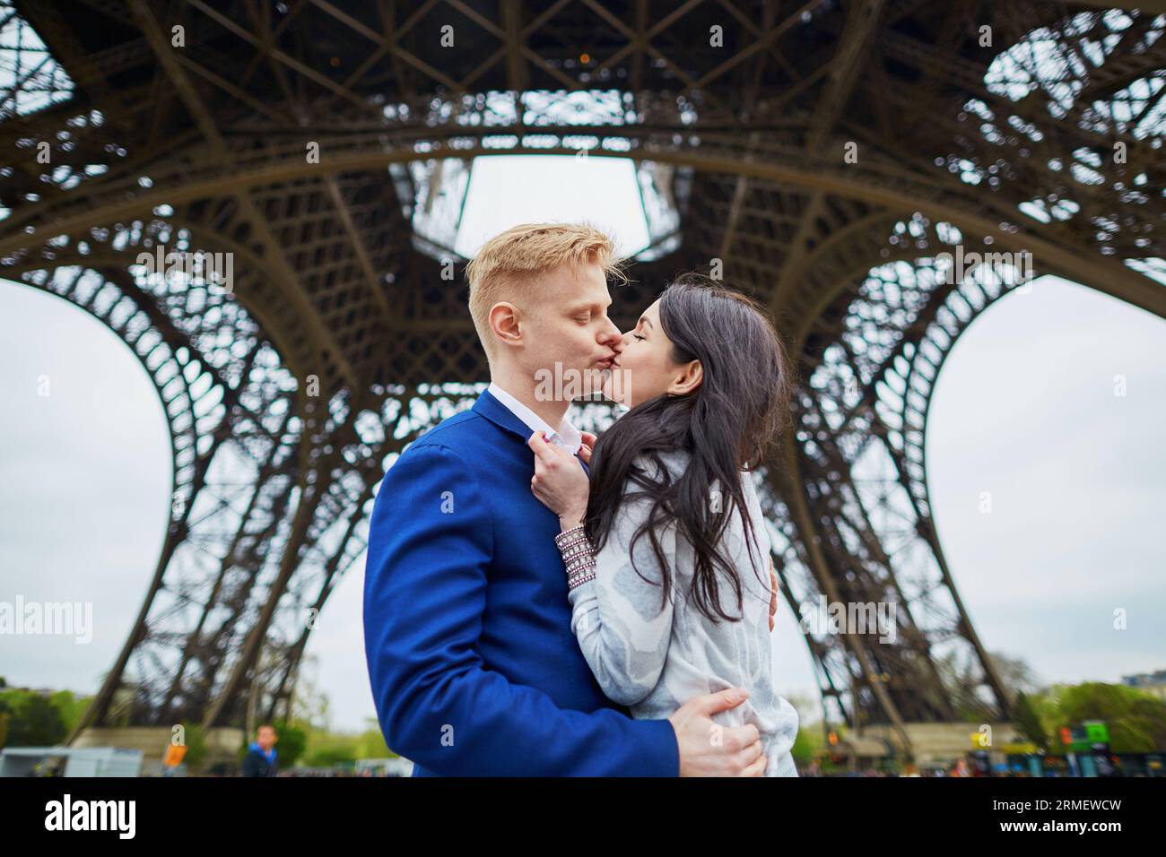 Glückliches Paar, das sich unter dem Eiffelturm küsst. Touristen, die ihren Urlaub in Frankreich genießen. Romantisches Date oder Konzept für ein reisendes Paar Stockfoto