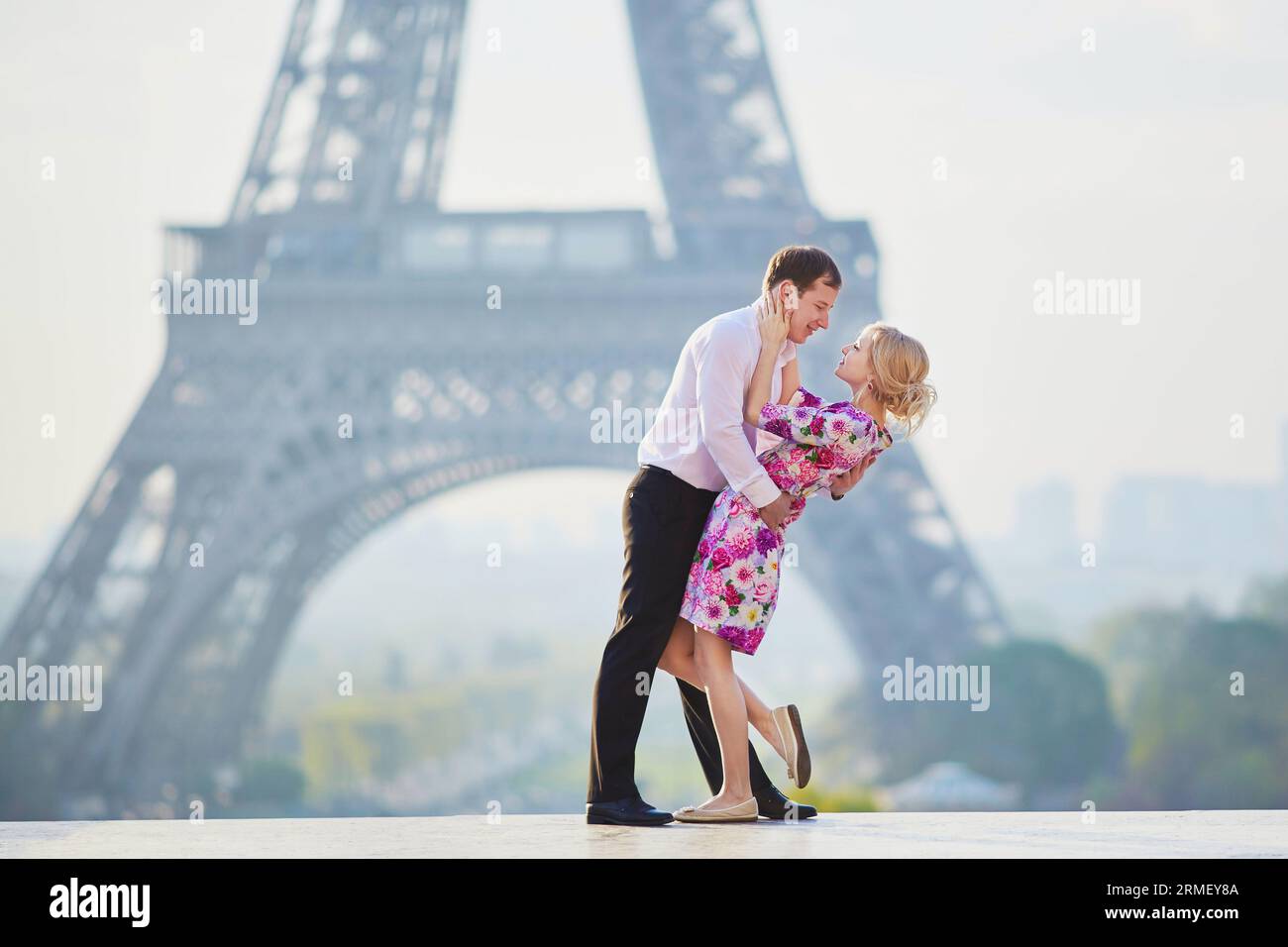Wunderschönes romantisches Paar, das sich vor dem Eiffelturm in Paris, Frankreich, umarmt Stockfoto
