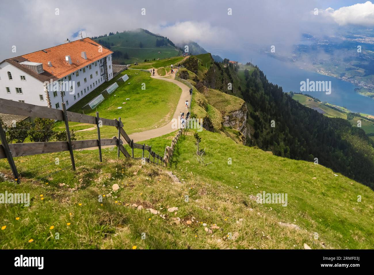 Besucher des Wanderweges Kulmweg auf dem Gipfel des Rigi Kulm, bewundern den malerischen Blick auf die bergige Landschaft von Central... Stockfoto