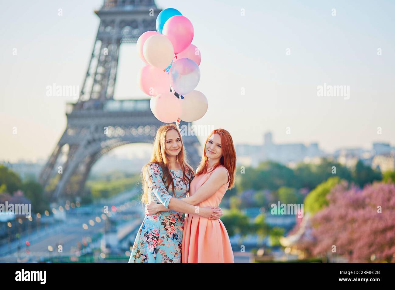 Zwei schöne junge Frauen mit Ballons in Paris in der Nähe des Eiffelturms Stockfoto