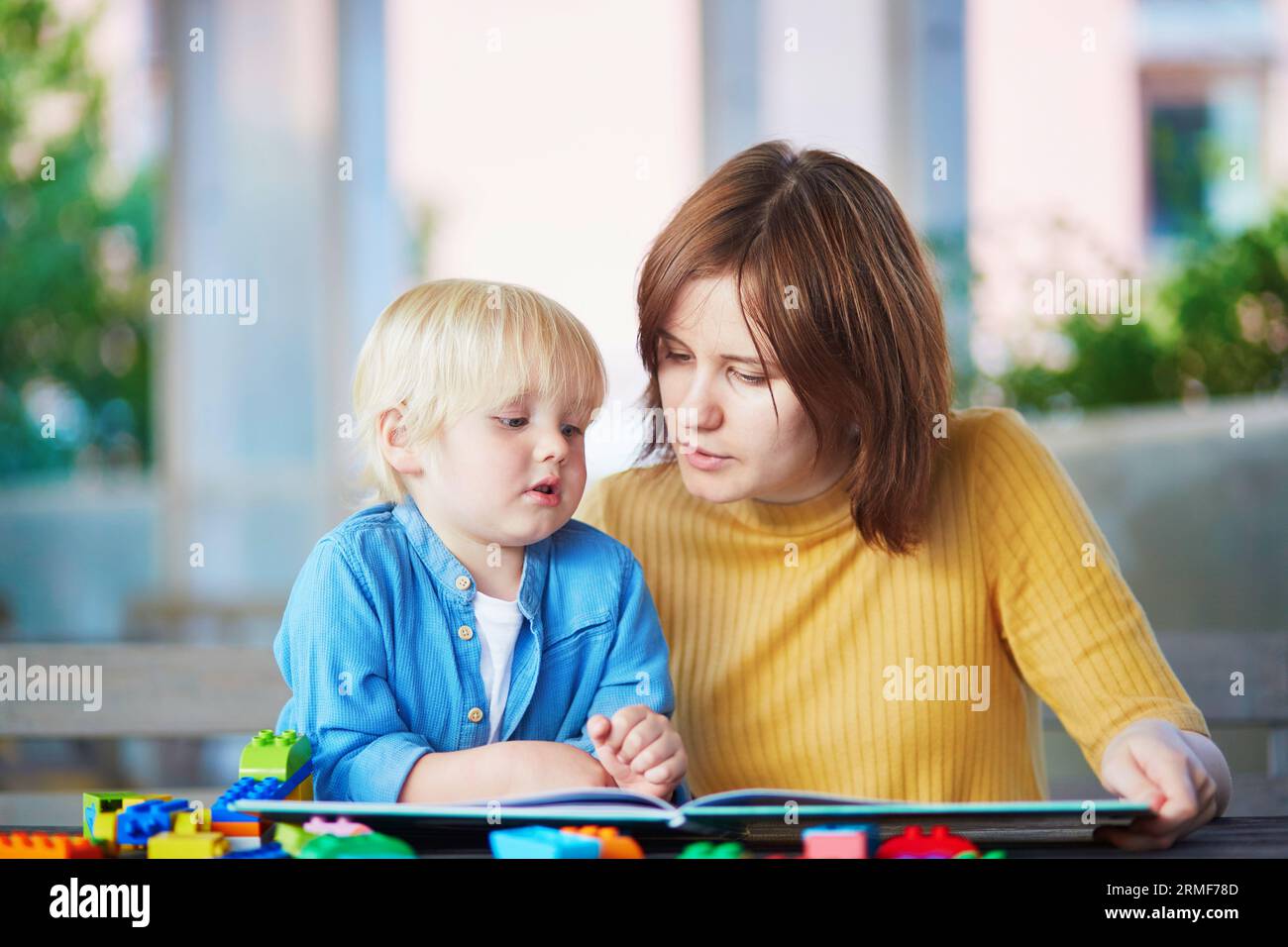 Junge Mutter, die ihrem Sohn Buch liest. Gute Familienzeit mit Kindern Stockfoto