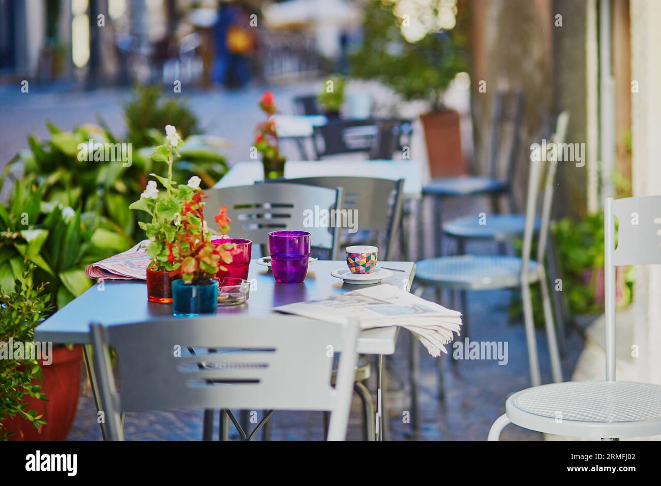 Gemütliches Café im Freien mit Kaffeetasse und Zeitung auf dem Tisch in Rom, Latium, Italien Stockfoto