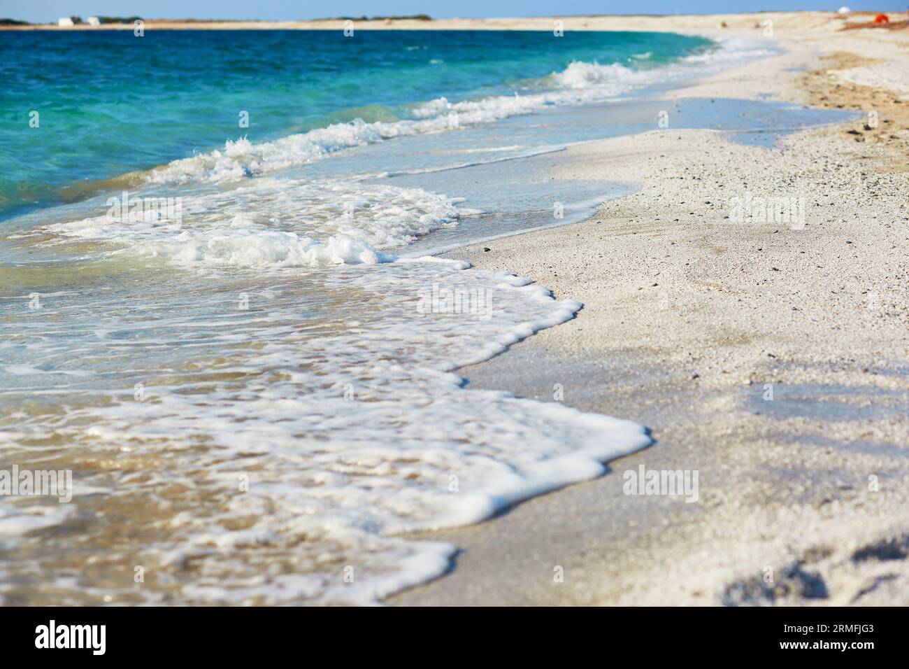 Blaues Wasser und viele weiße Körner auf dem Strand Arutas, bekannt als Reisstrand in Sardinien, Italien Stockfoto